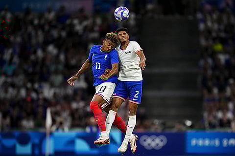 Desire Doue and Nathan Harriel battle for a head ball